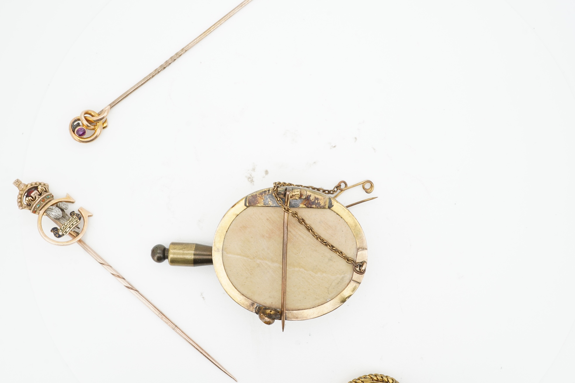 A collection of jewels, comprising: a stick pin, capped with the 'C' cipher with crowned ostrich feather and 'Ich Dien' motto for King Charles when Prince of Wales, in varicoloured gold and enamel, length 6.9cm, gross we